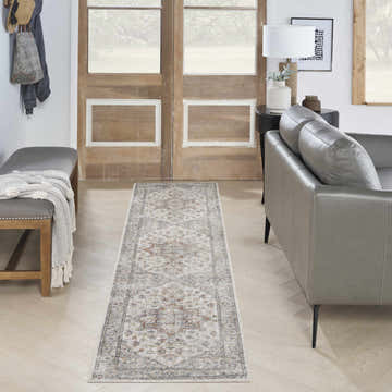 Entryway with grey sofa, bench, and Nourison Astra Grey Multicolor Vintage Runner Rug on light wood floors.
