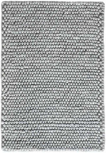 Close-up of the textured DKNY Pure Knots Denim rug. The handmade, mid-century modern rug has a pile material and a denim color.