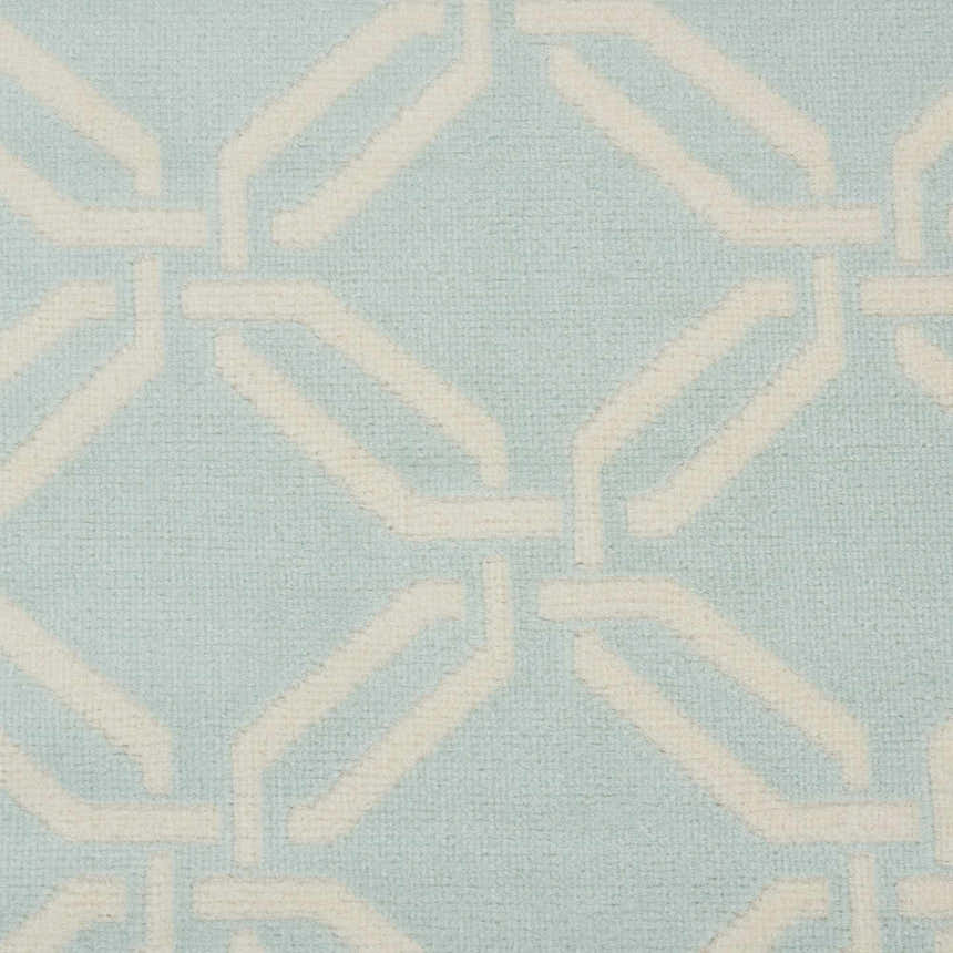 Close up of the Nourison Jubilant Green rug. Features a geometric, ivory trellis pattern on a light green background.