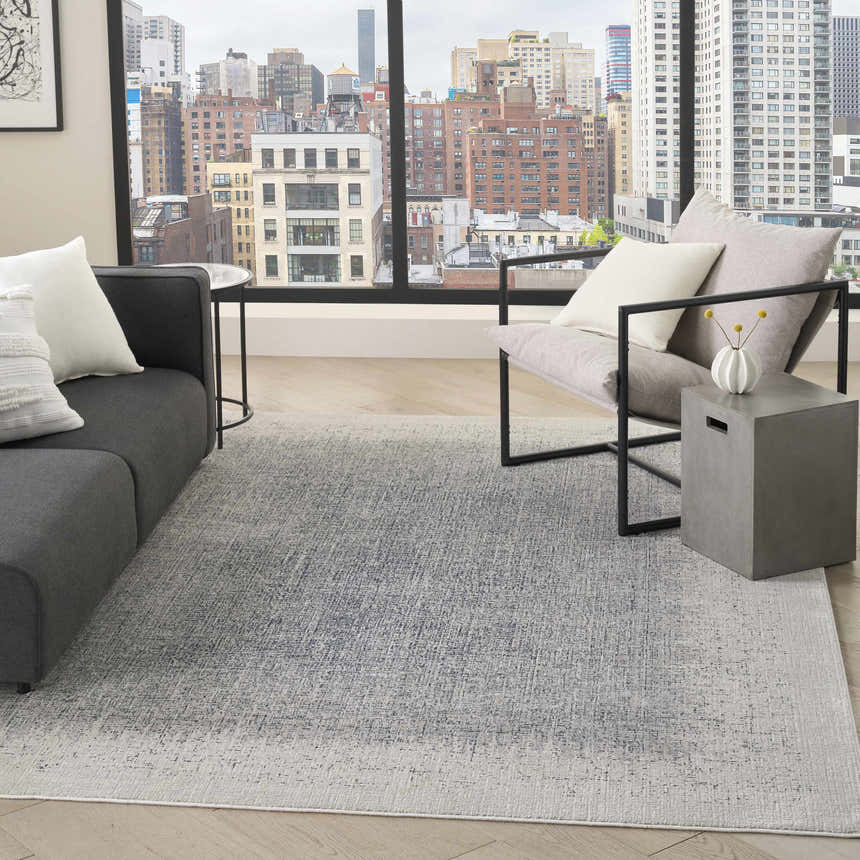 Modern living room with gray sofa and DKNY Grand Street Ivory Blue Area Rug.