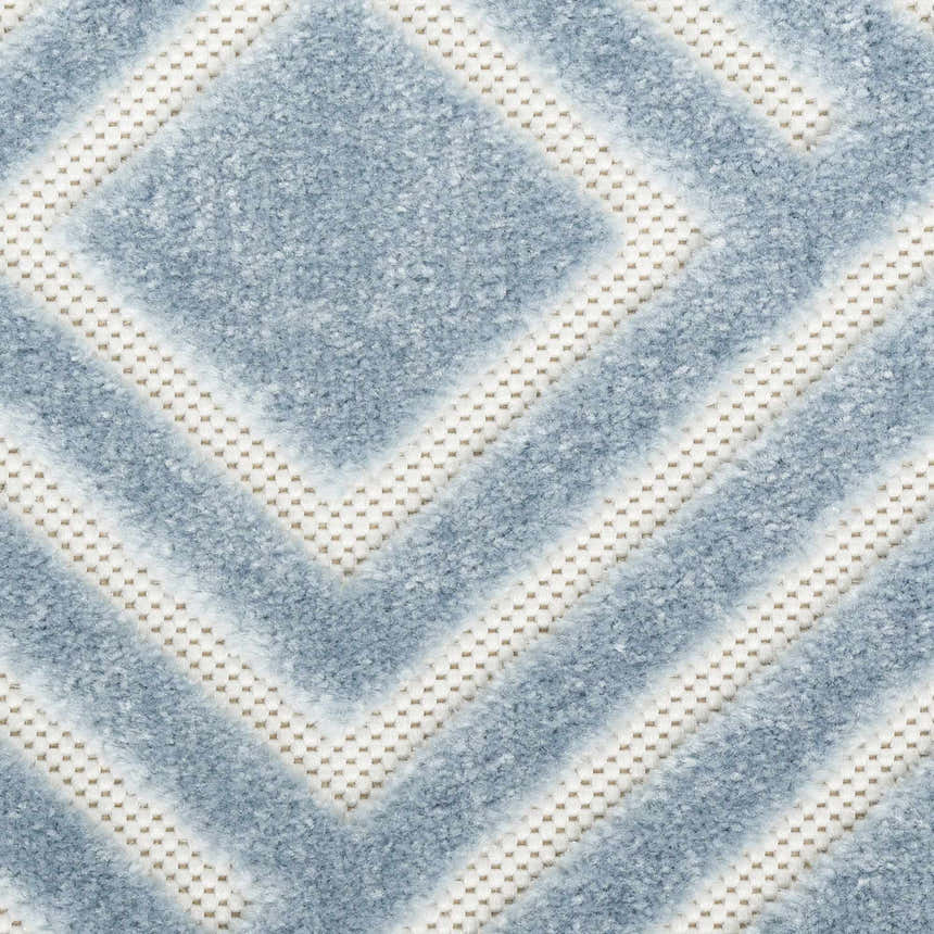 Close-up of Nourison Care Free Blue rug. Modern geometric design with light blue and ivory hues. Soft texture.