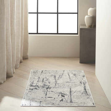 Minimalist entryway with Calvin Klein CK970 Vapor Ivory Grey rug, neutral curtains, and modern decor.