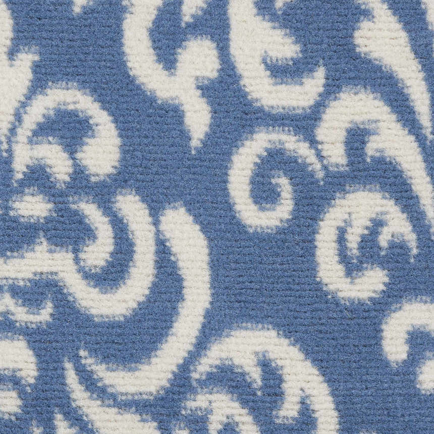 Close-up of the Nourison Grafix Blue Vintage Area Rug showing its light blue and white swirling pattern.