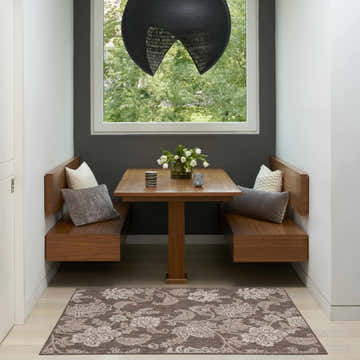 Breakfast nook with wood benches and Nourison Garden Oasis Mocha Tropical Area Rug.