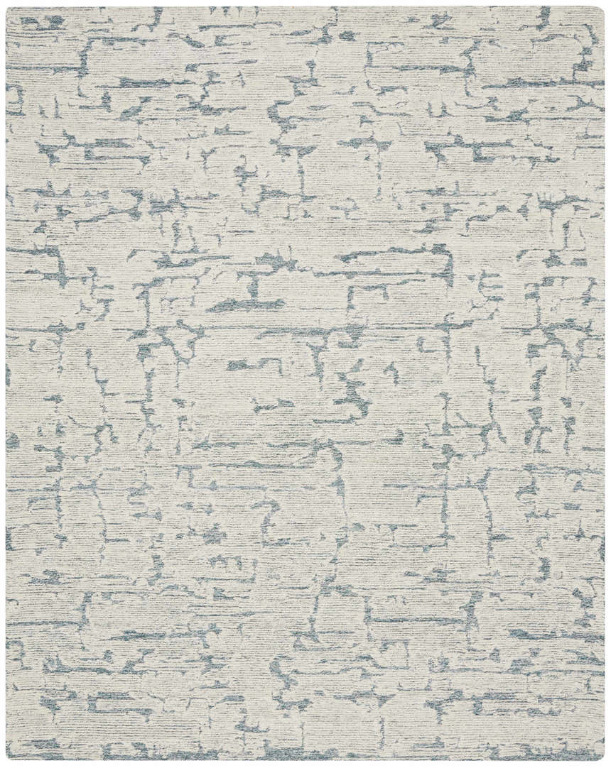 Close-up of the Calvin Klein CK009 Sculptural Teal rug. Modern, handmade wool rug with a subtle geometric pattern.