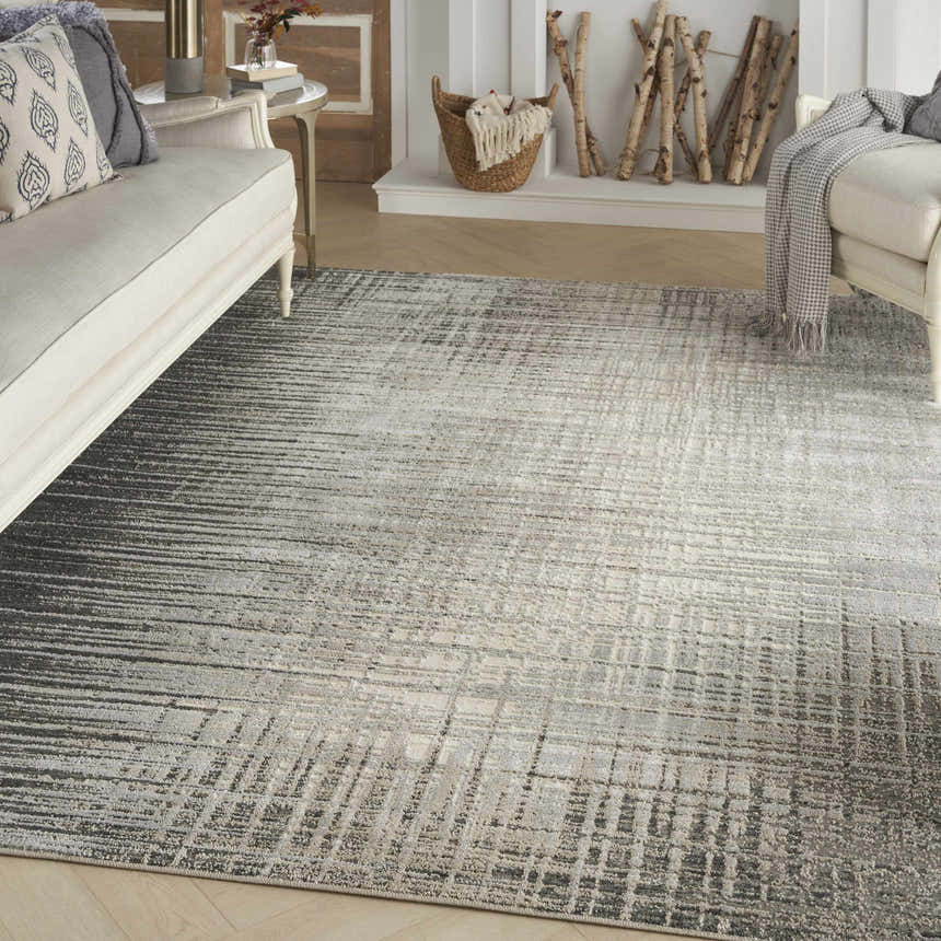 Living room scene with a Nourison Marmara grey and ivory rug, cream sofas, and a decorative fireplace.