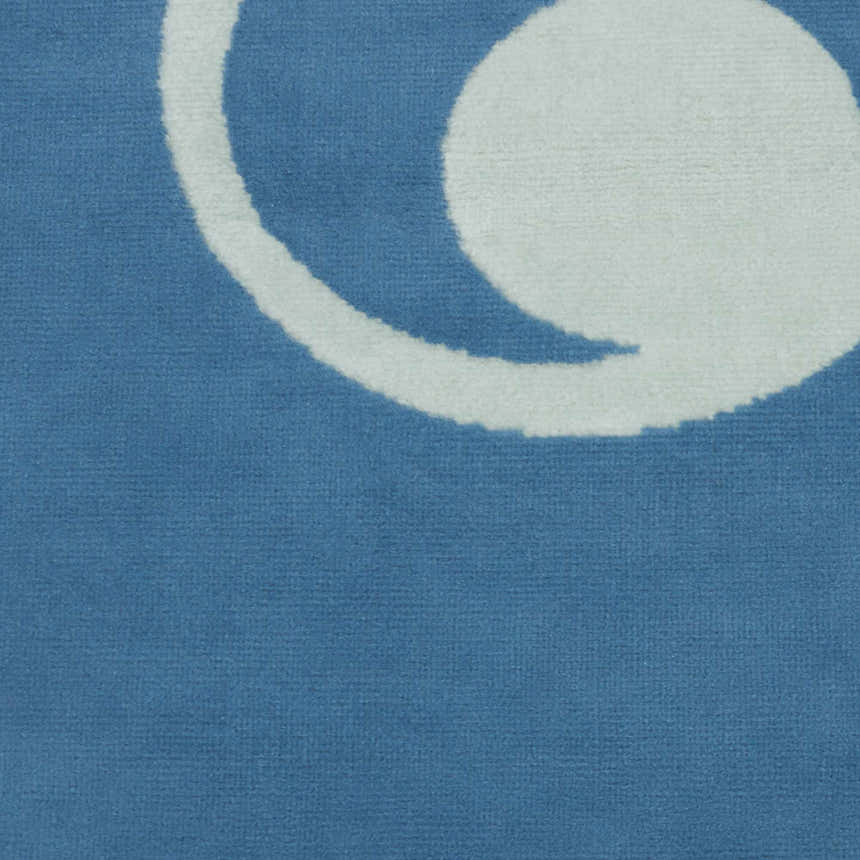 Close-up of the blue Nourison Grafix area rug with a white circular design.