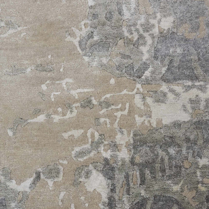 Close-up of the Nourison Silk Shadows Sand rug showing sandstone, gray, and white abstract pattern and silk-like texture.