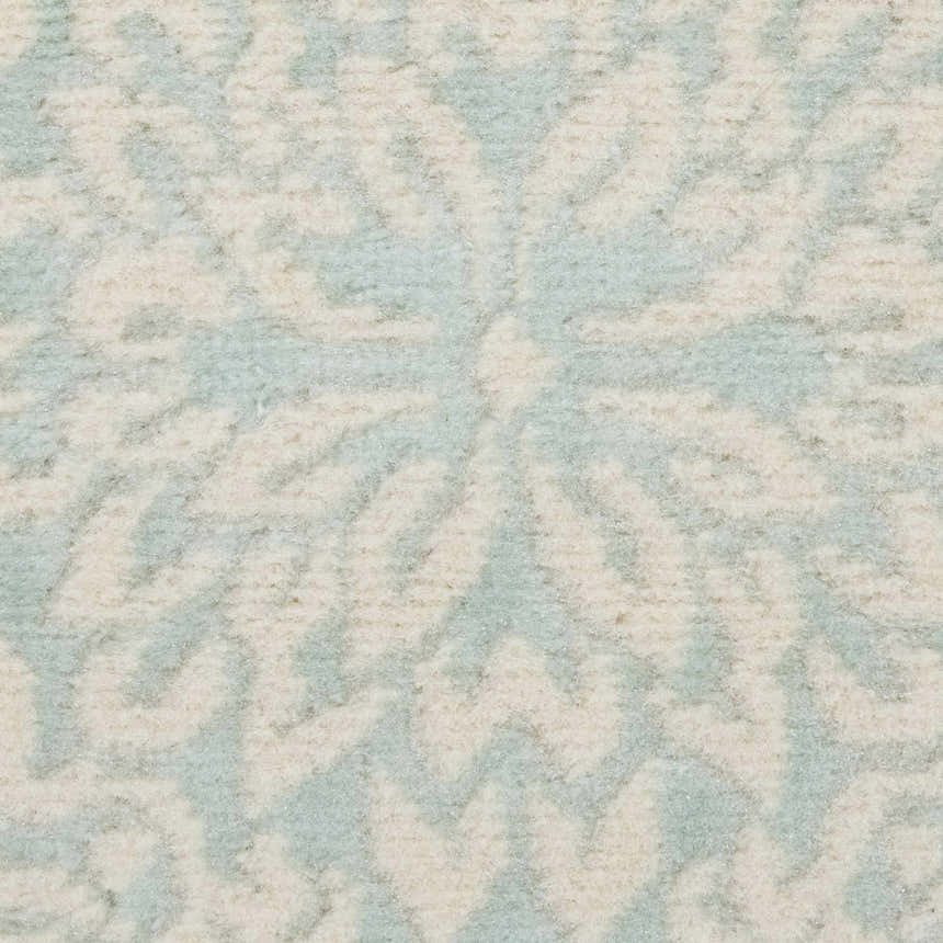 Close-up of the Nourison Jubilant Ivory Green rug, showing its farmhouse pattern and soft, textured polypropylene material.
