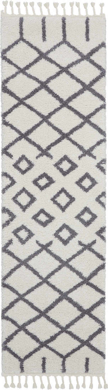 Close-up of Nourison Moroccan Shag White Tribal rug. Features a diamond pattern and tassels. Shag texture.