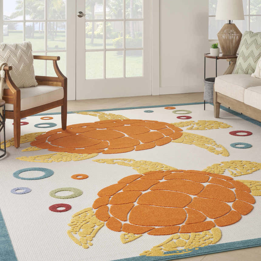 Coastal living room with Nourison Aloha Teal Multicolor rug featuring orange turtles and colorful circles.