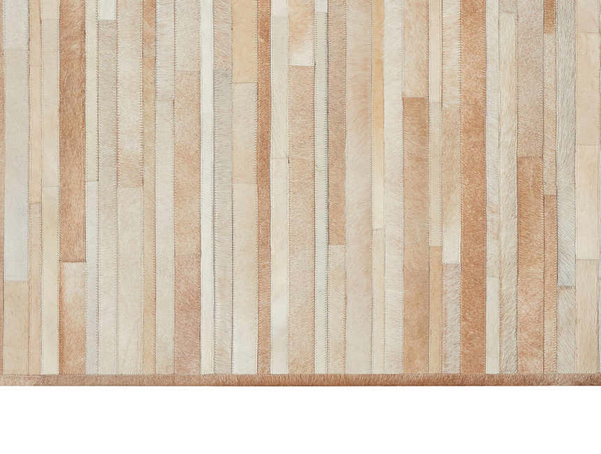 Close-up of Calvin Klein Home Prairie Beige rug. Modern design with beige and cream hair on hide stripes. Handmade texture.