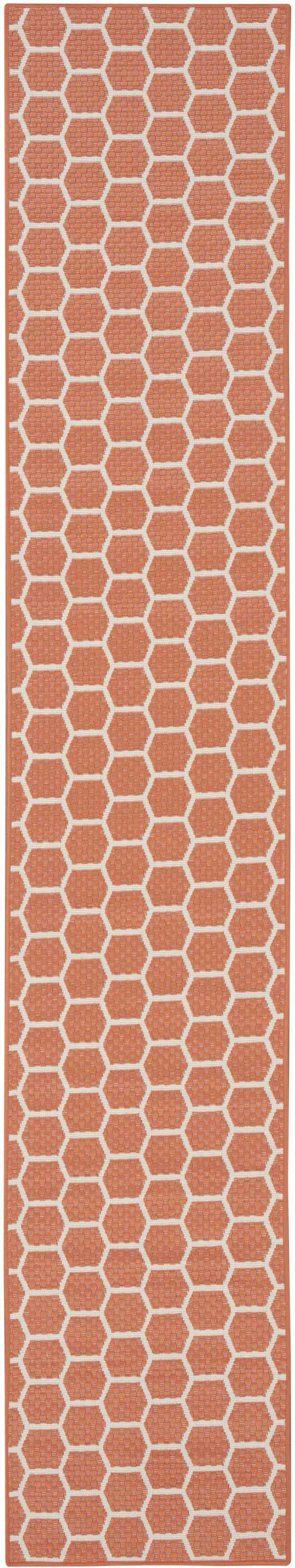 Close-up of Nourison Twist Reversible Coral Modern Area Rug with a geometric honeycomb pattern. Coral and white color.