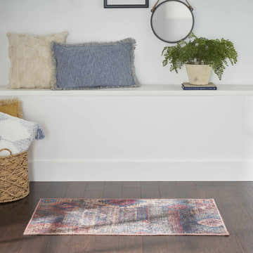 Entryway with a Nourison New Concept Multicolor Vintage rug on dark wood floors. Pillows and decor on a shelf.