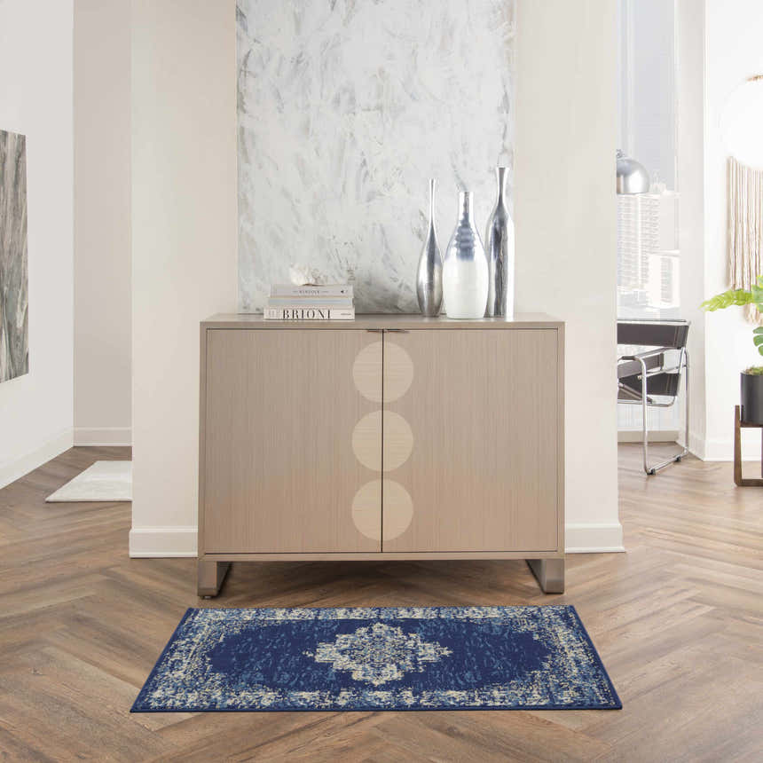 Entryway with wood floors and a Nourison Grafix Navy Blue Vintage rug in front of a modern cabinet.