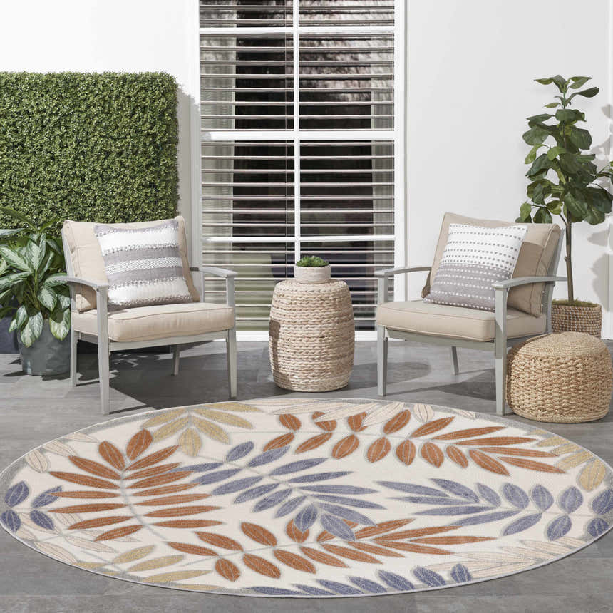 Outdoor patio scene with a Nourison Aloha Blue Mocha oval rug, chairs, and plants.