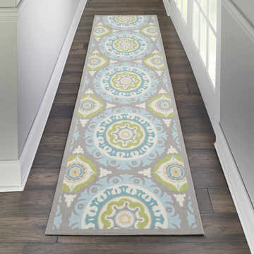 Hallway with Waverly Sun N' Shade Jade runner rug. Coastal style, medallion pattern in jade, blue, and gray on dark wood floor.