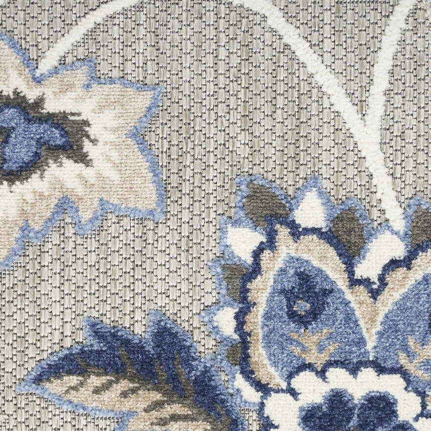 Close-up of Nourison Aloha Blue Grey Outdoor Area Rug showing floral pattern, blue, gray, and white colors.
