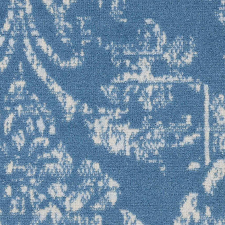 Close-up of the Nourison Jubilant Blue Vintage Area Rug showing its light blue and white distressed pattern.