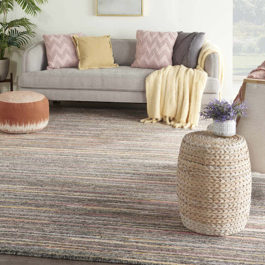 Living room scene with a Nourison Plateau Grey Flame rug, gray sofa, and woven accents.