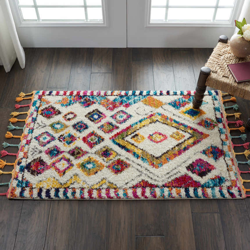 Entryway scene with Nourison Nomad Ivory Multicolor Tribal rug, dark wood floors, and a woven chair.