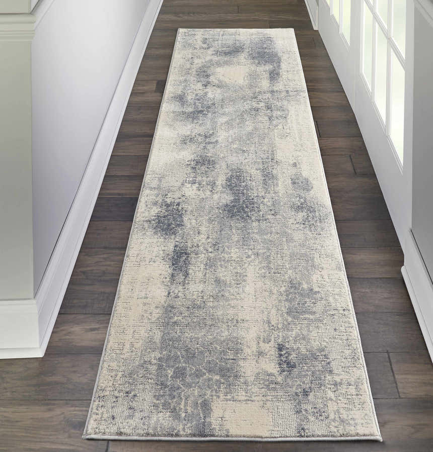 Hallway with Nourison Rustic Textures Blue Ivory runner rug on dark wood floor, white walls and door.