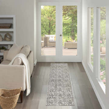 Hallway with a Nourison Serenity Home grey ivory runner rug, leading to patio doors and outdoor seating. Neutral tones.