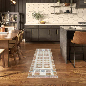 Modern kitchen with Nourison Nordic Ivory Rust rug runner, wood floors, dark cabinets, and island.