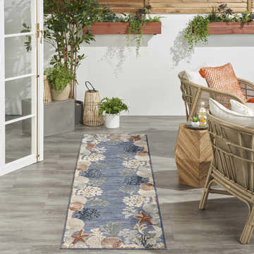 Coastal patio with rattan chairs and Nourison Suncoast Denim Multicolor area rug.