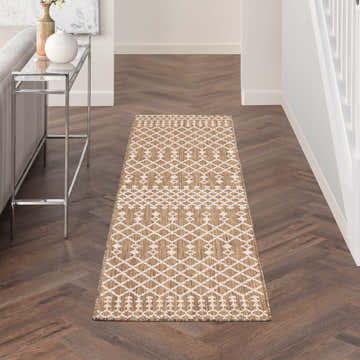 Hallway with Nourison Positano Jute Modern Area Rug runner on herringbone wood floor. White geometric pattern.