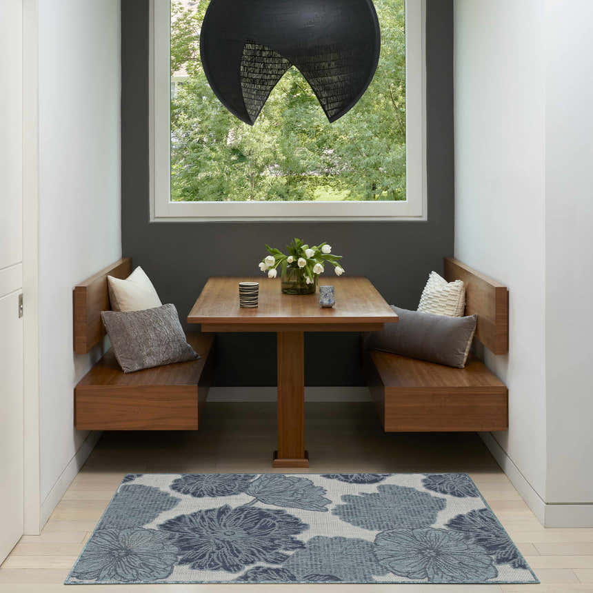 Breakfast nook with wood benches and Nourison Garden Oasis Blue Tropical Area Rug.
