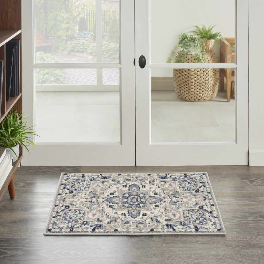 Entryway scene with a Nourison Passion Grey Beige rug, wood floors, and white french doors to a garden.