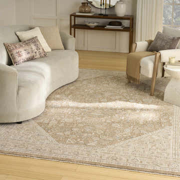 Living room scene with a light brown Nourison Retreat Mocha Vintage Indoor Area Rug, sofa, and chair.