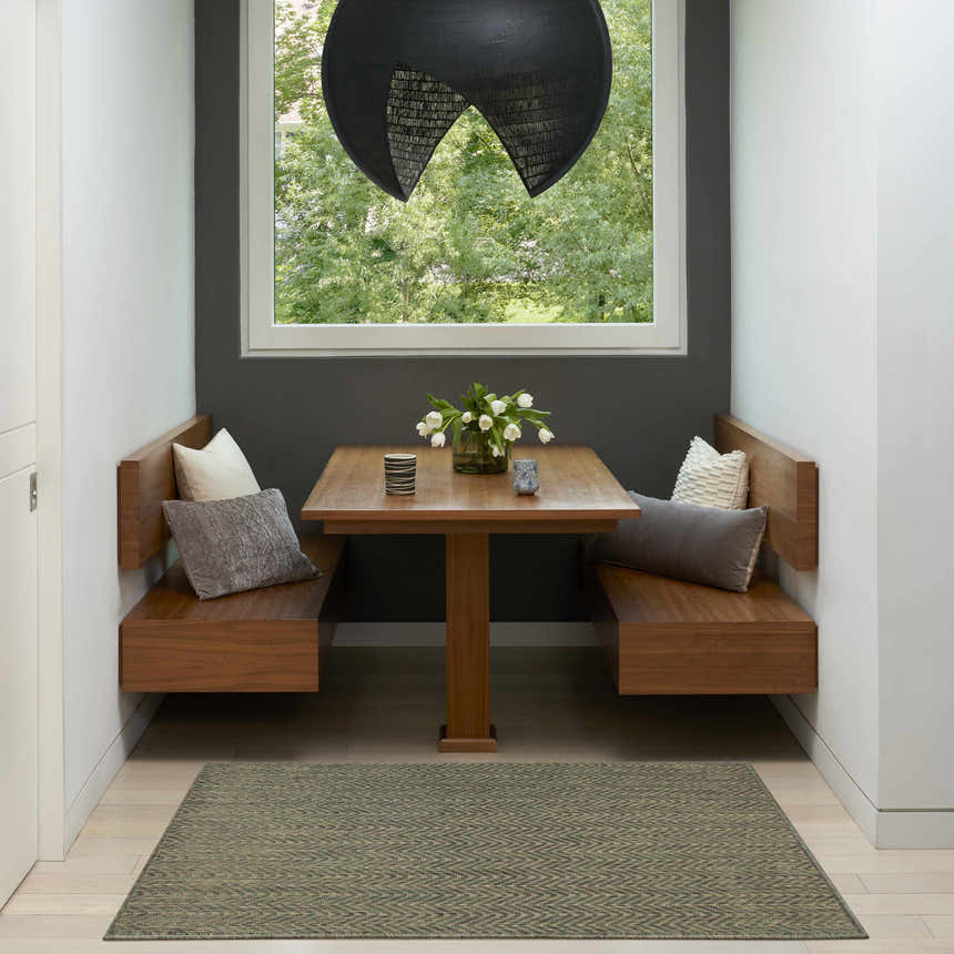 Modern dining nook with wood benches and a Nourison Horizon Green rug with a subtle herringbone pattern.