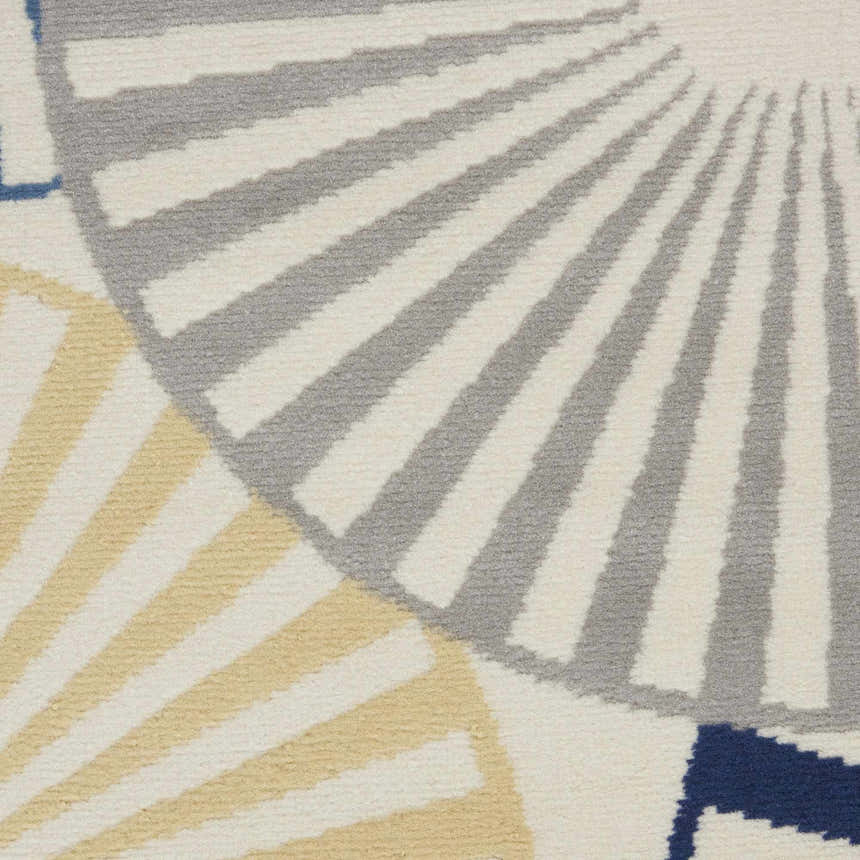 Close-up of the Nourison Grafix White rug featuring an abstract fan pattern in off-white, gray, yellow, and blue.