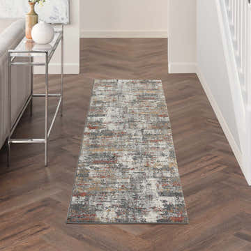 Hallway with a Nourison Tangra Grey Multicolor rug, wood floors, white walls, and a silver console table.
