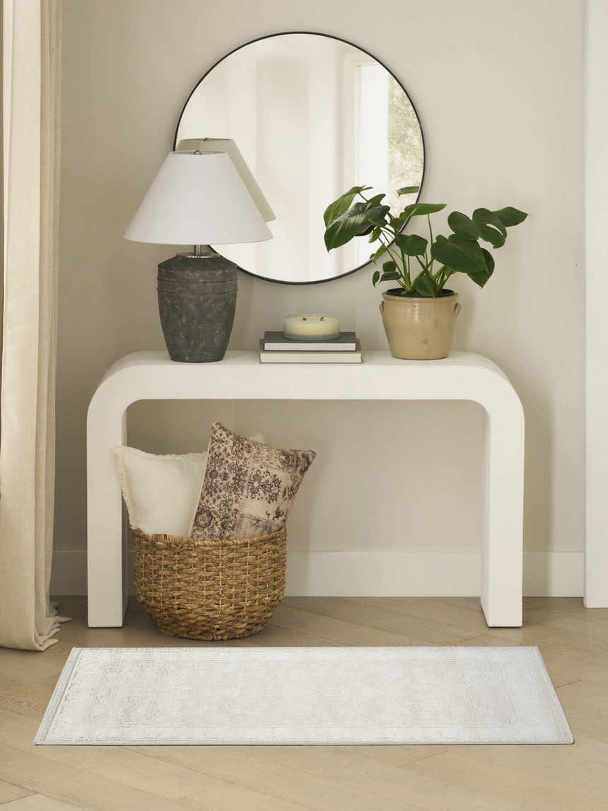 Entryway with white console table, round mirror, and light gray vintage Nourison Dekor area rug.