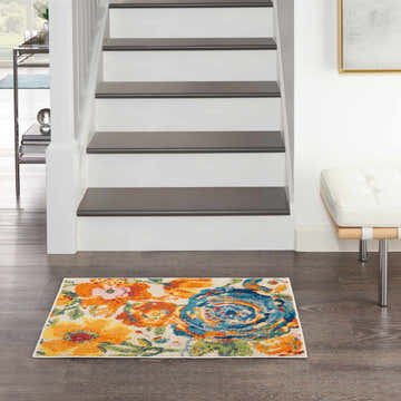 Entryway with Nourison Allur Ivory Multicolor rug. Floral runner at the base of stairs on dark wood floor.