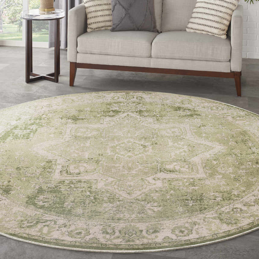 Living room scene with a round Nourison Astra Ivory Green Vintage rug under a sofa.