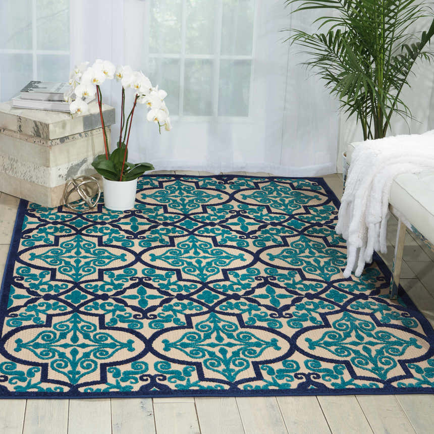 Bright living room with a Nourison Aloha Navy Bohemian Area Rug, white furniture, and natural light.