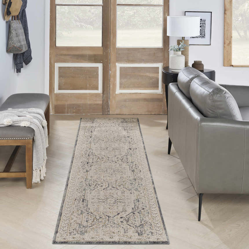 Entryway with a Nourison Lynx Ivory Charcoal Vintage rug, gray leather sofa, and wood accents.