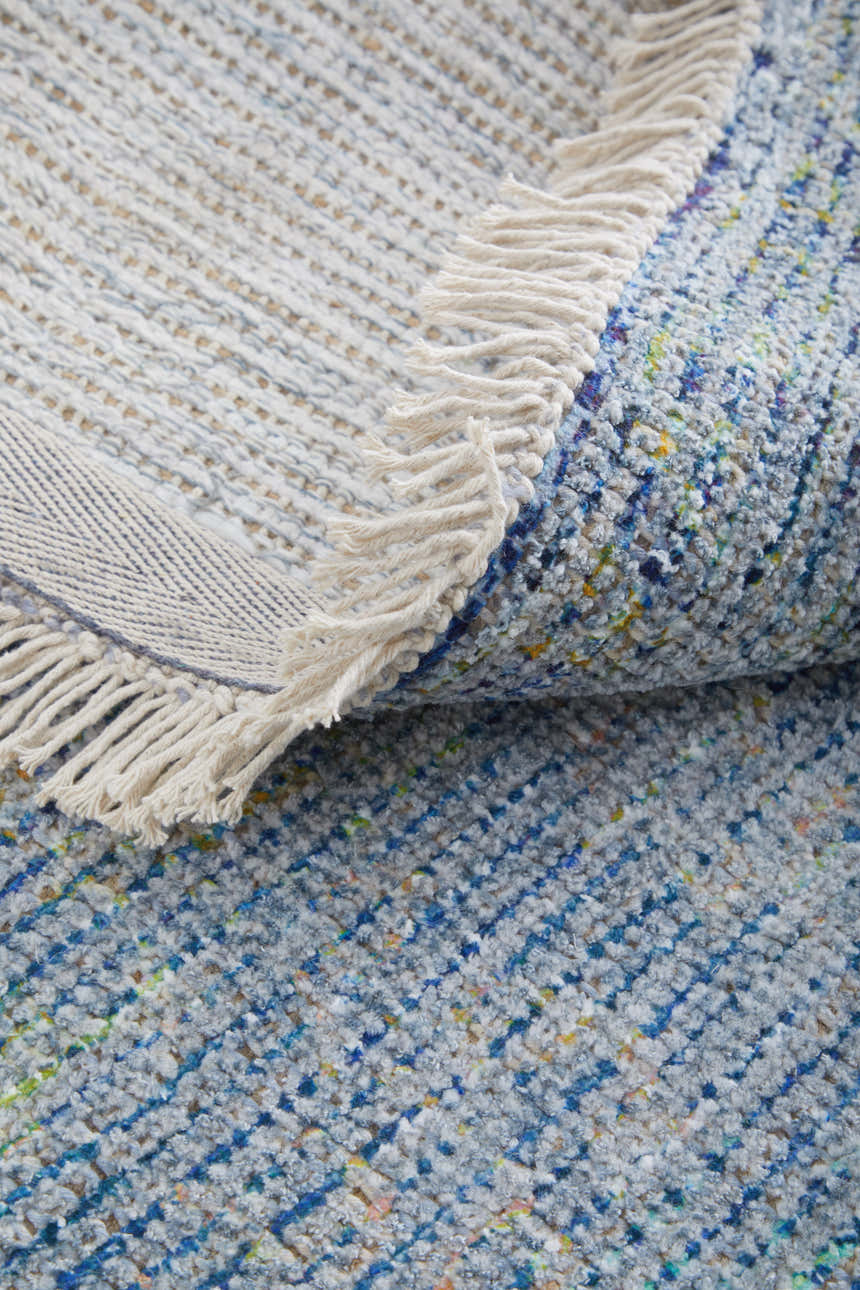 Close-up of the Feizy Caldwell rug in blue and gray, showing texture, weave, and fringe detail. Fold