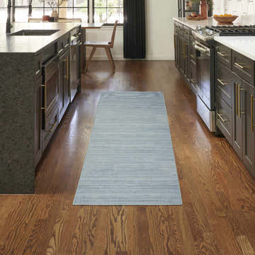 Aqua Nourison Essentials runner rug in a modern kitchen with dark wood cabinets and hardwood floors.