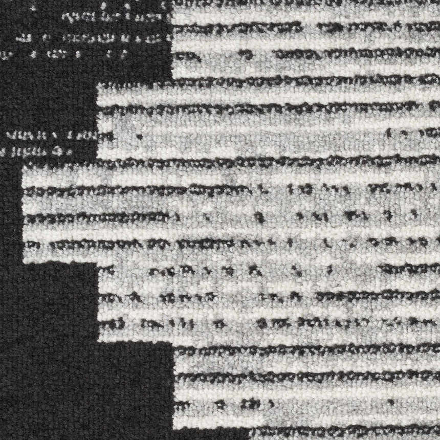 Close-up of the Nourison Modern Passion Black Grey rug showing its mid-century modern pattern and textured polypropylene material.