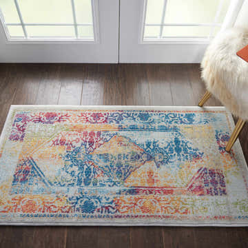 Entryway with Nourison Ankara Global rug in ivory and multicolor. Bohemian rug on dark wood floors with white doors.