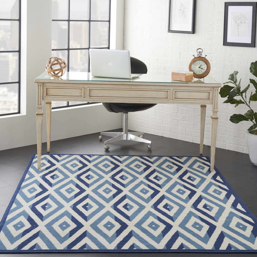 Home office with Nourison Grafix White Blue rug, desk, laptop, and city view. Mid-century modern style.