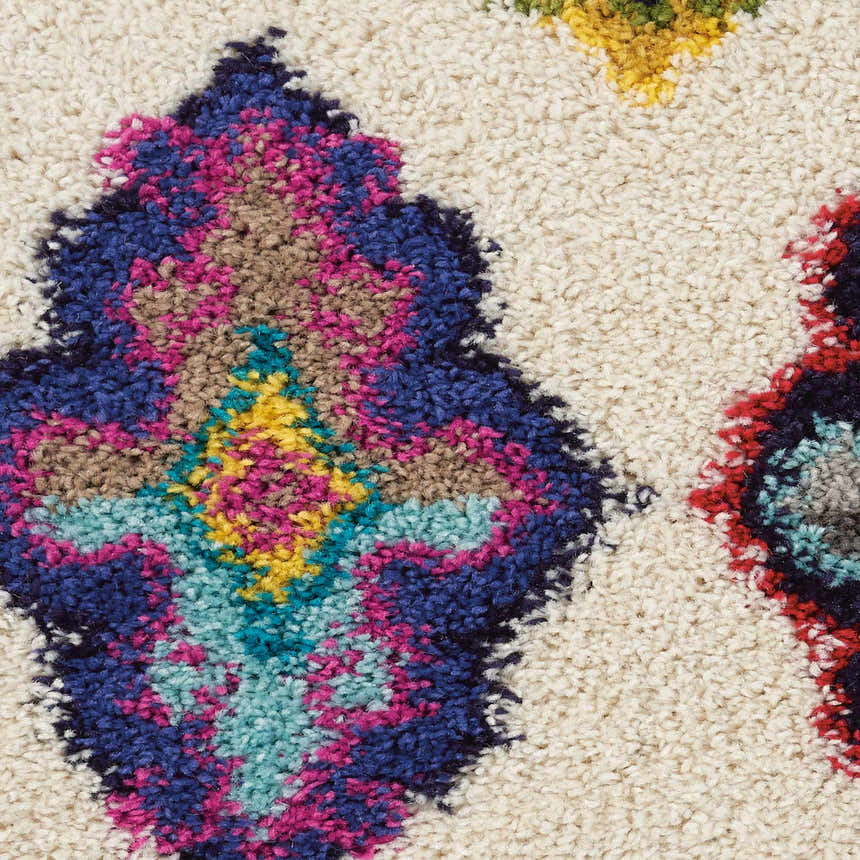 Close-up of the Nourison Nomad rug: ivory shag texture with blue, pink, red, and yellow floral pattern.