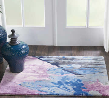 Entryway with Nourison Prismatic Grey Multicolor rug, dark wood floor, blue ceramic vases, and white window.