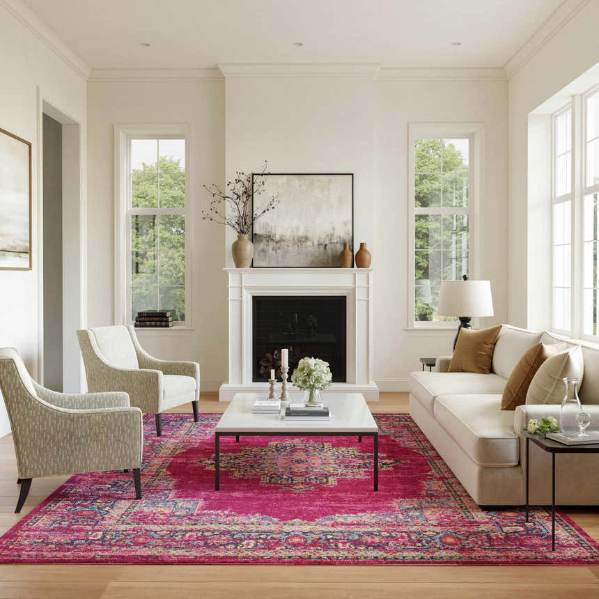 Living room scene with a Nourison Passion Fuchsia rug, white sofa, chairs, fireplace, and wood floors.