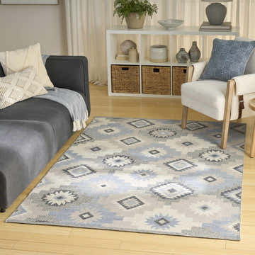Living room scene with a Nourison Copenhagen Ivory Blue rug, gray sofa, and white armchair.